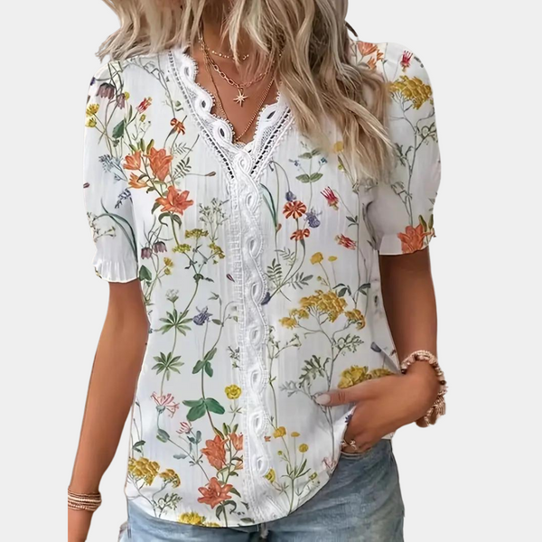 Elegant bluse med blomstermønster og delikat kant